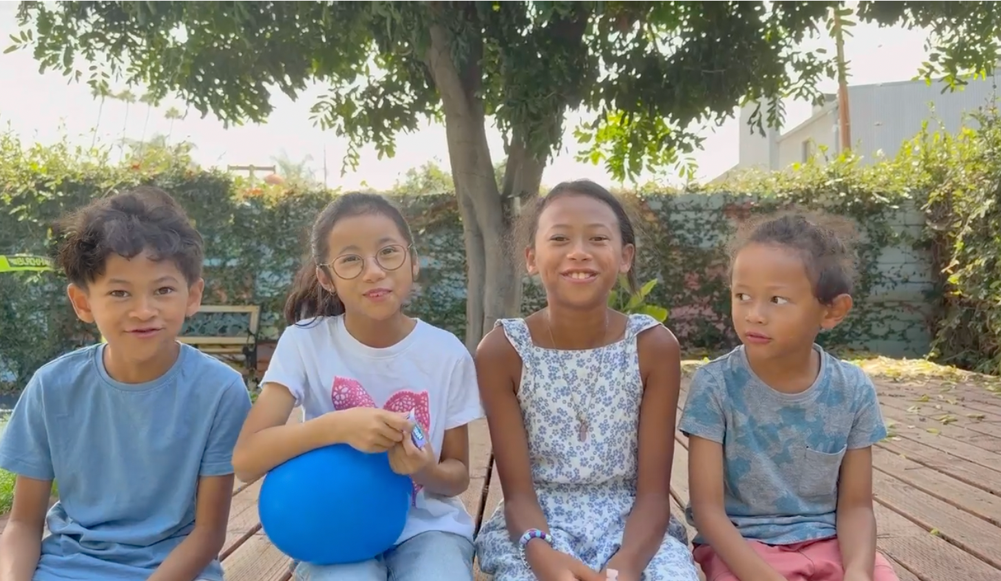 Four children sharing and listening together during an outdoor eq2 activity